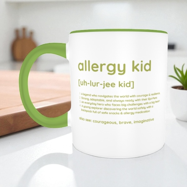 White mug with green handle featuring text about 'allergy kid' on a kitchen counter.
