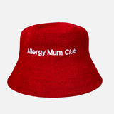 Red bucket hat with 'Allergy Mum Club' text on a light gray background