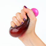Hand holding a purple and brown stress ball against a white background