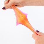 Colorful slime being stretched between two hands on a white background