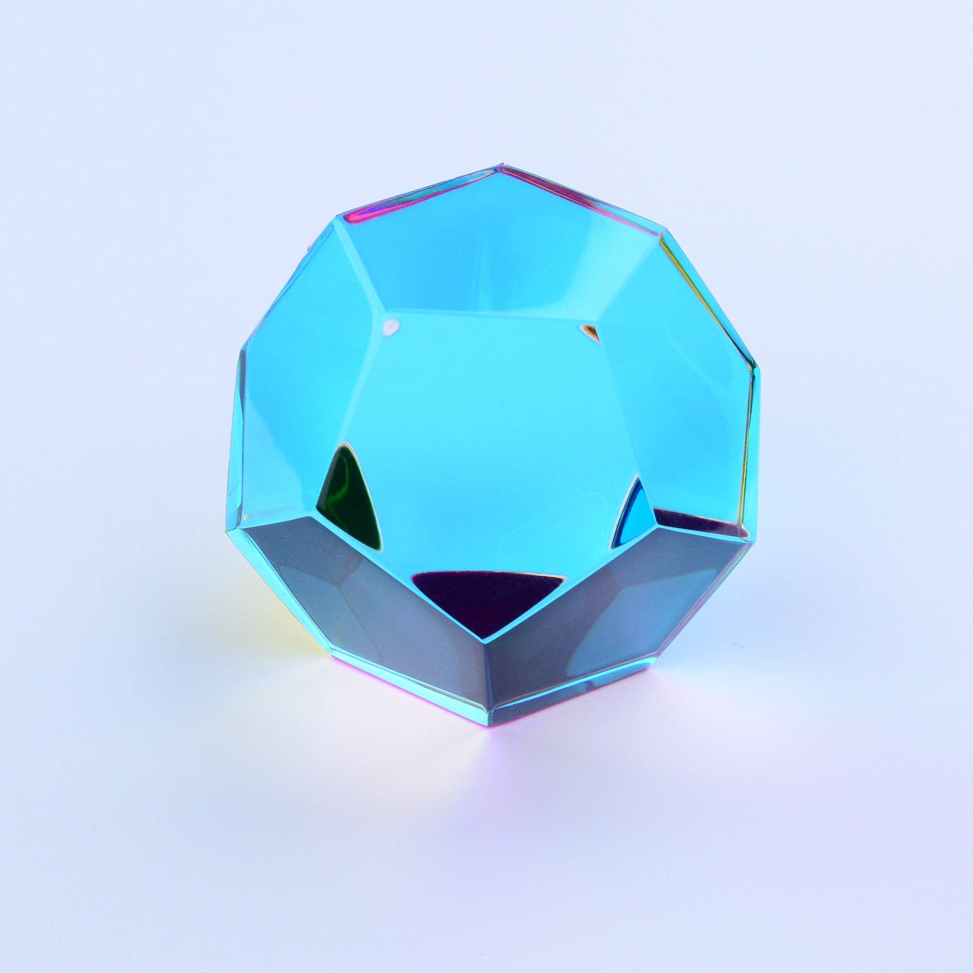 Faceted crystal object that is a dodecahedron toy on a gradient background 