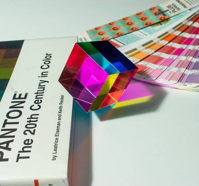 Colorful geometric object on a book titled 'Pantone: The 20th Century in Color' with color swatches in the background.