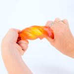 Two hands stretching a colorful, stretchy gel on a white background