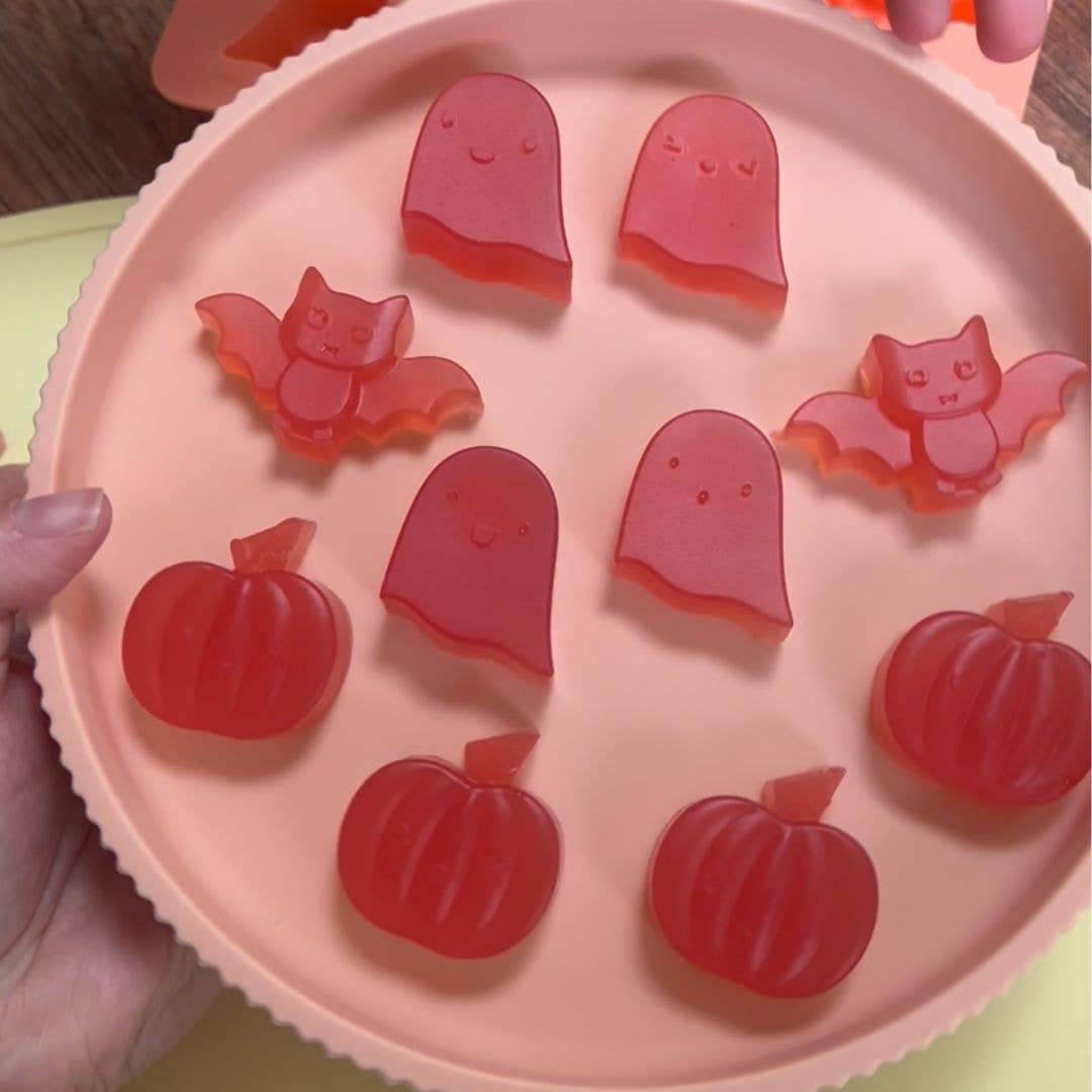 Pink plate with red jelly mould shapes of pumpkins, ghosts, and bats.