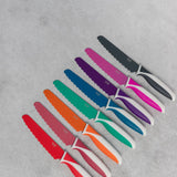 Set of colorful knives on a gray surface