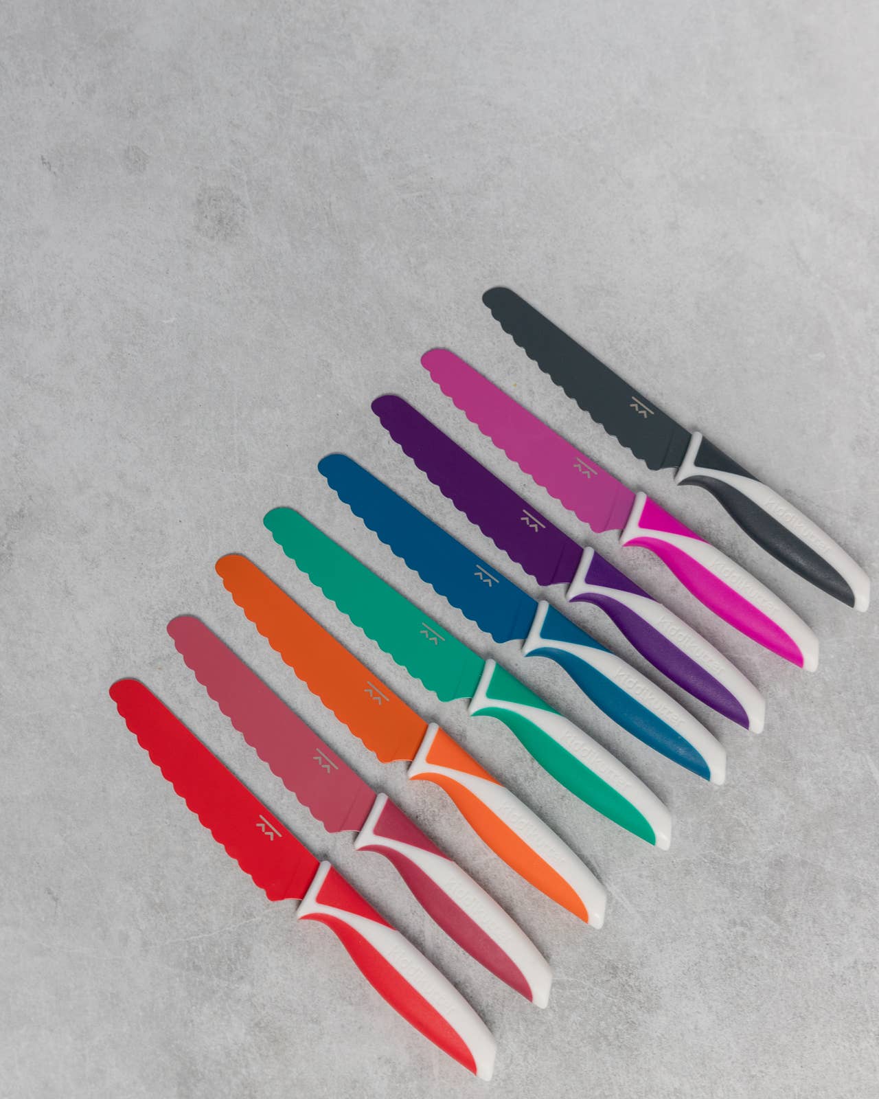 Set of colorful knives on a gray surface