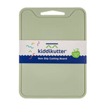 A sage green Kiddikutter non-slip cutting board with its white and blue paper packaging band around the center, shown on a plain white background.