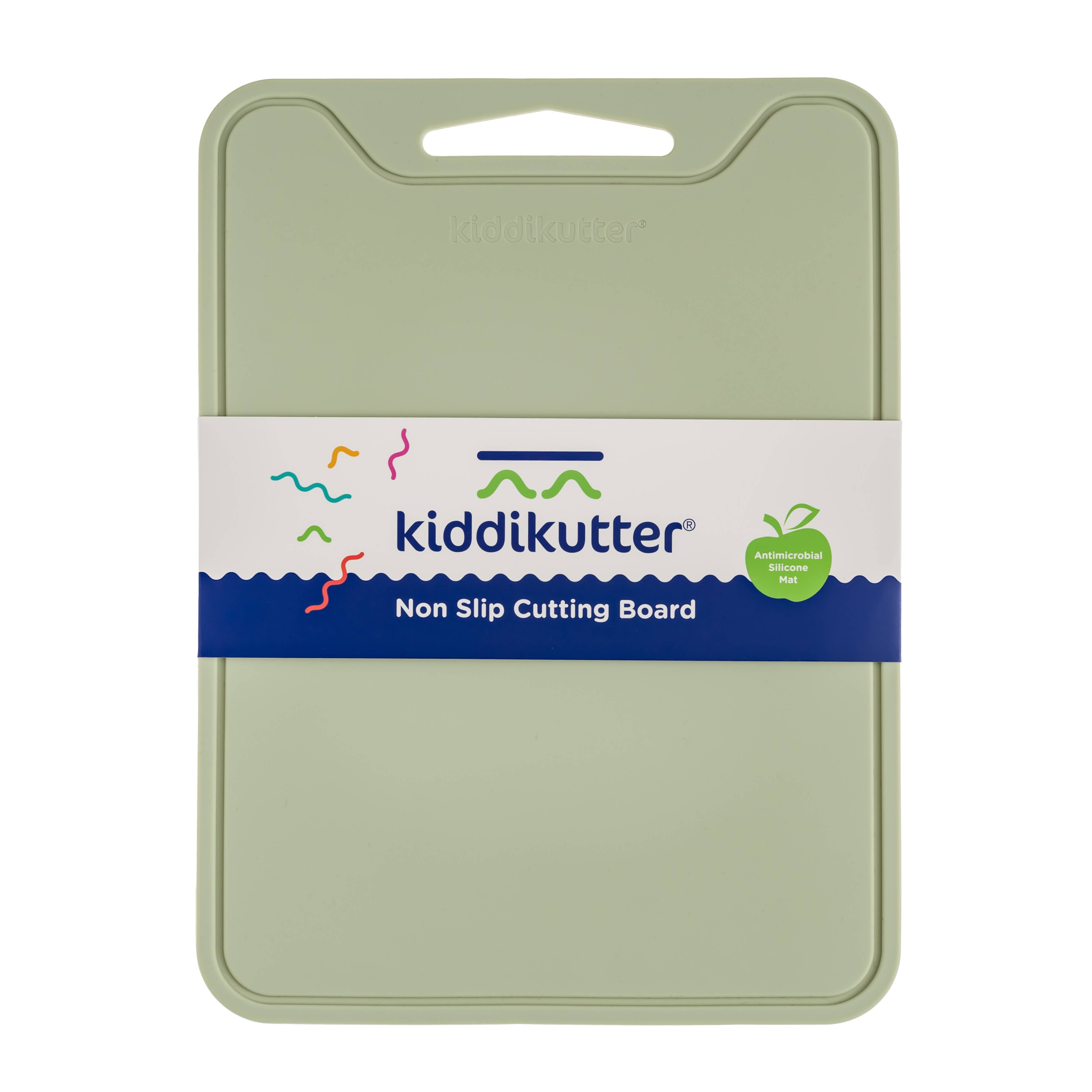 A sage green Kiddikutter non-slip cutting board with its white and blue paper packaging band around the center, shown on a plain white background.