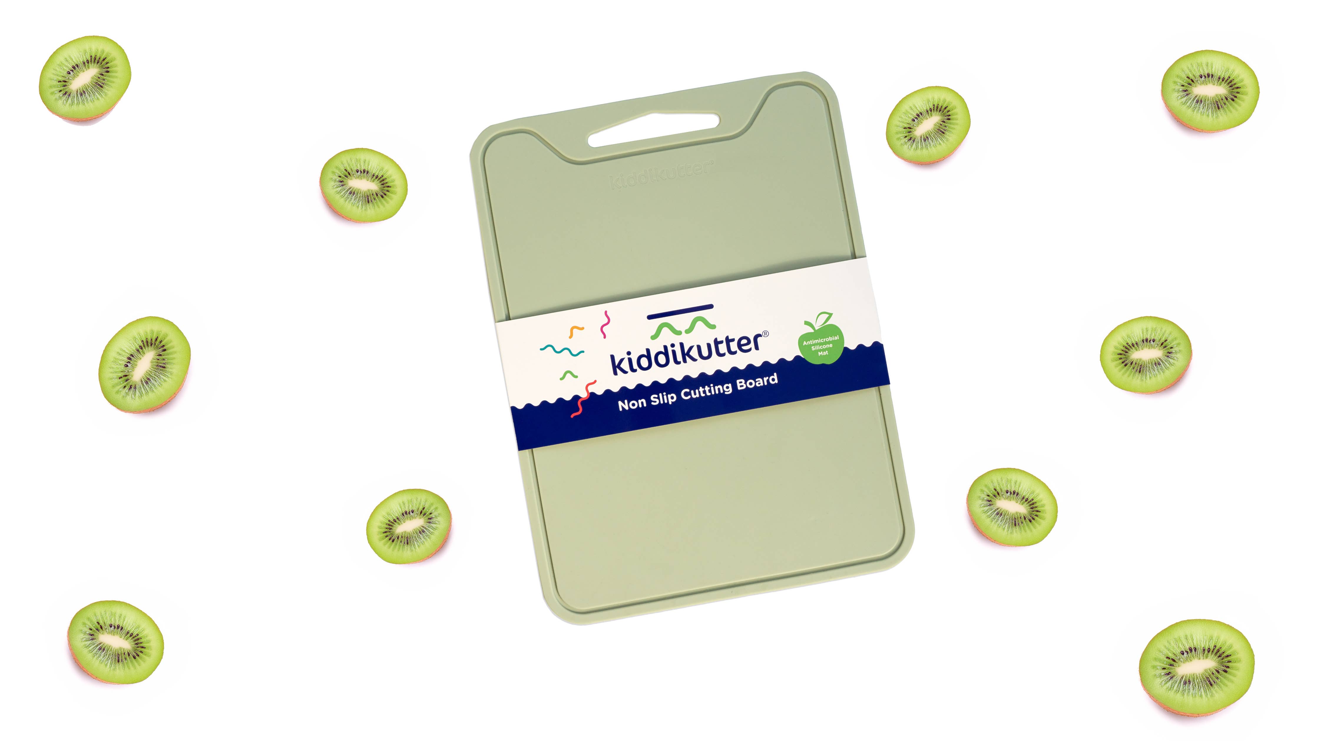A light green kiddikutter non-stick cutting board with a white and navy paper label, shown on a white background with floating sliced kiwi fruit illustrations around it.
