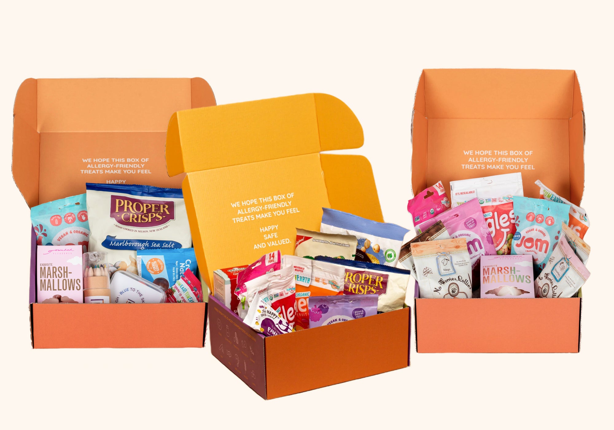 Three orange gift boxes filled with various treats on a white background