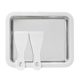Stainless steel tray with two white spatulas on a white background