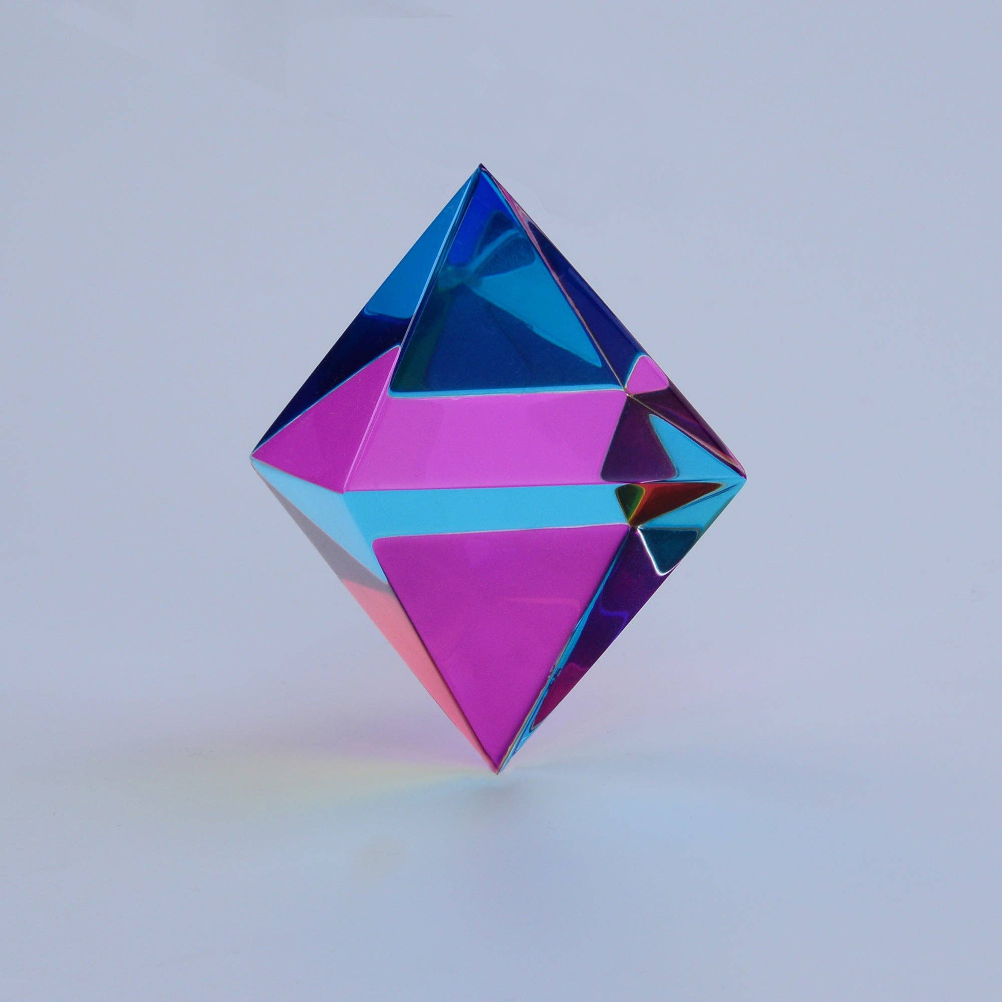 Multicoloured geometric prism on a light gray background