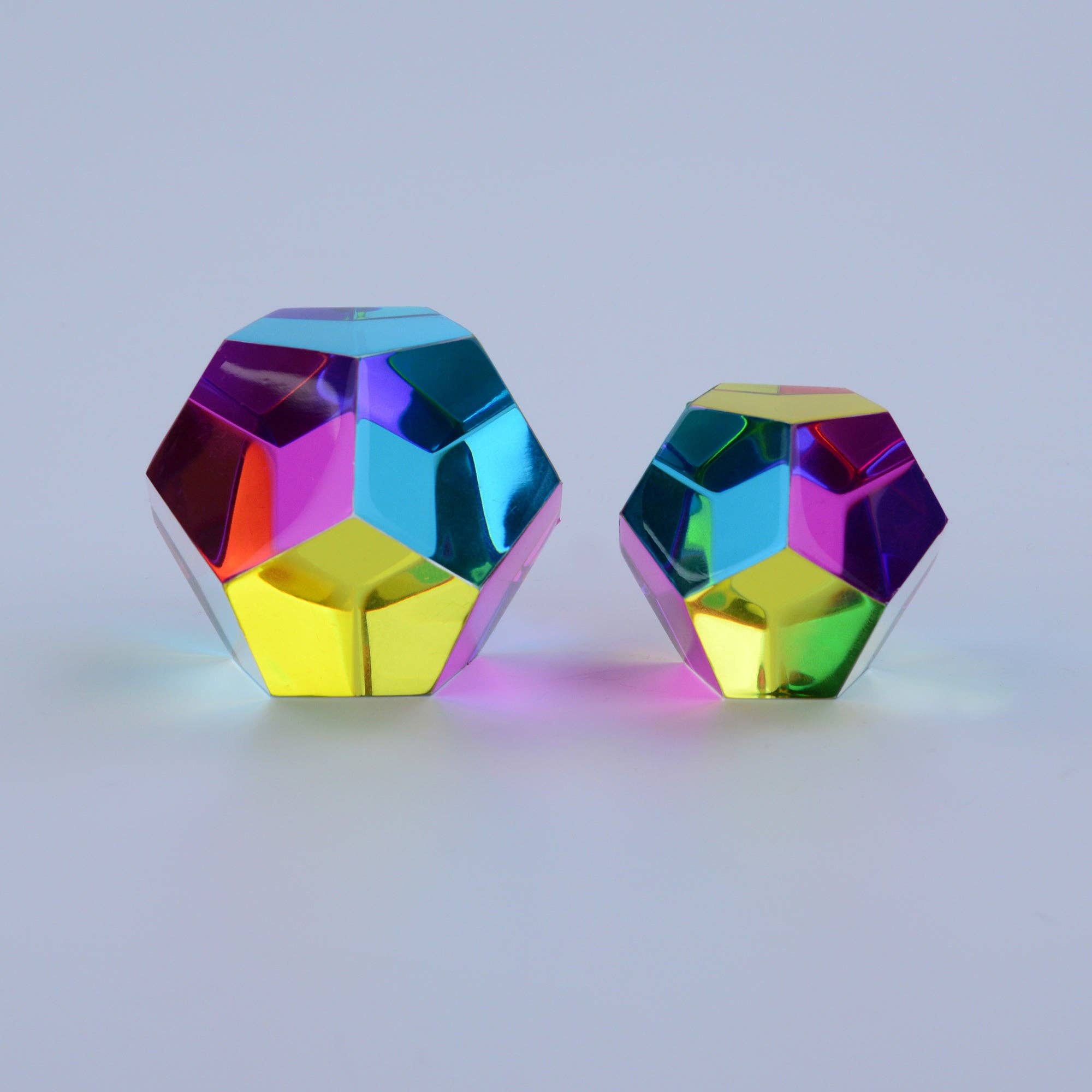 Two colorful geometric objects on a light gray background